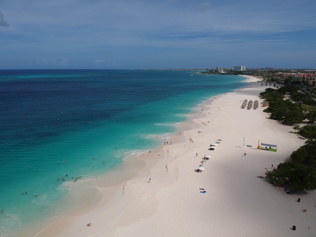 Stunning aerial photograph of a pristine sandy beach in Aruba with clear blue waters.