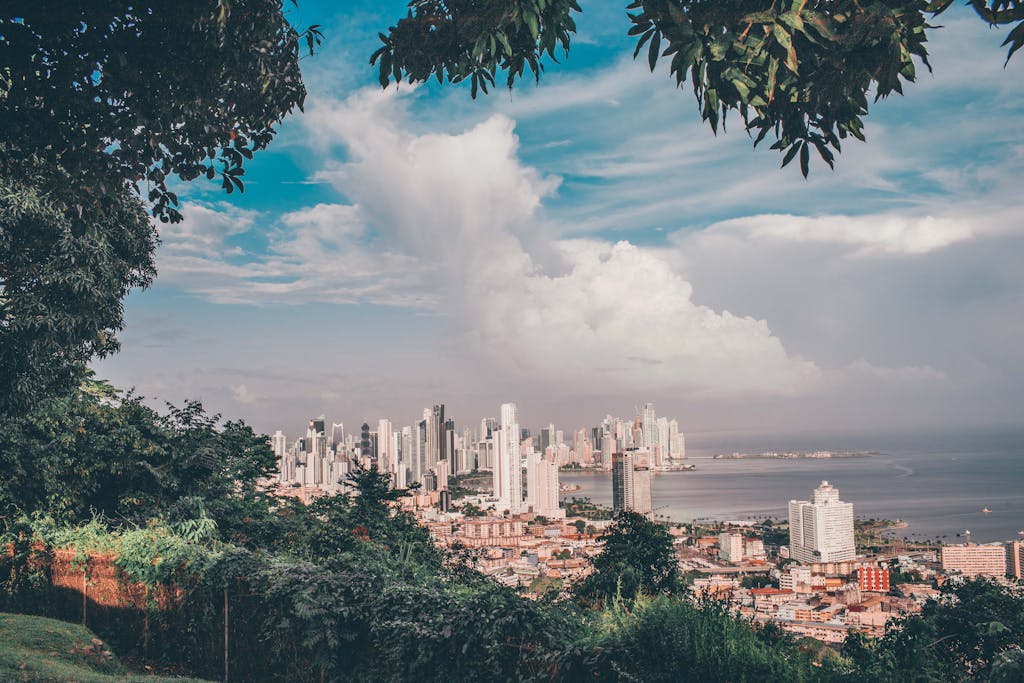 Scenic view of Panama City skyline under a vibrant sky with lush green foreground.