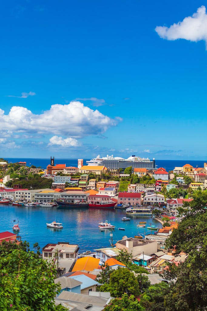 Vibrant harbor view in St. George's, Grenada with colorful buildings and boats under a bright blue sky.