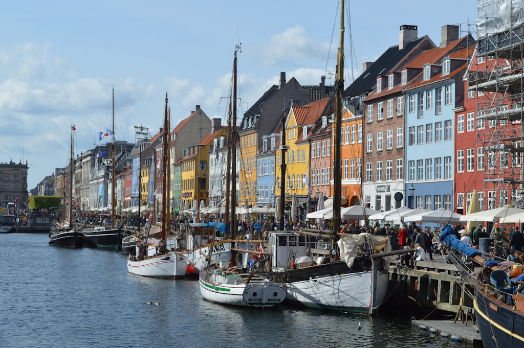 Vibrant waterfront scene of Nyhavn harbor with historic buildings and boats in Copenhagen.