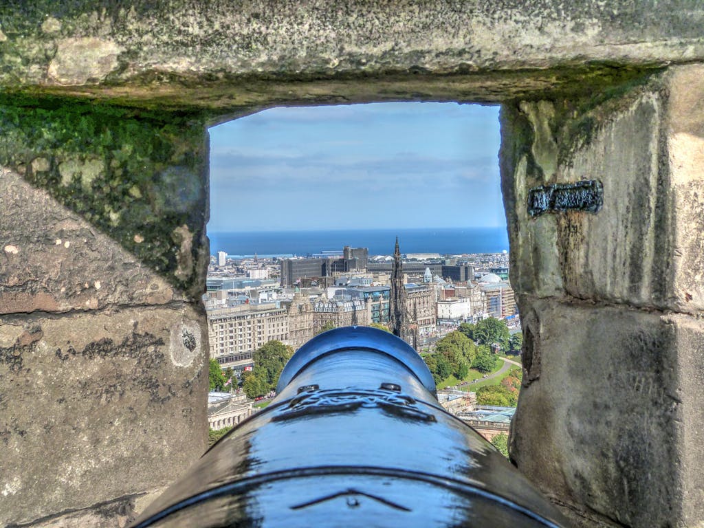 View from Edinburgh Castle cannon overlooking city and ocean.